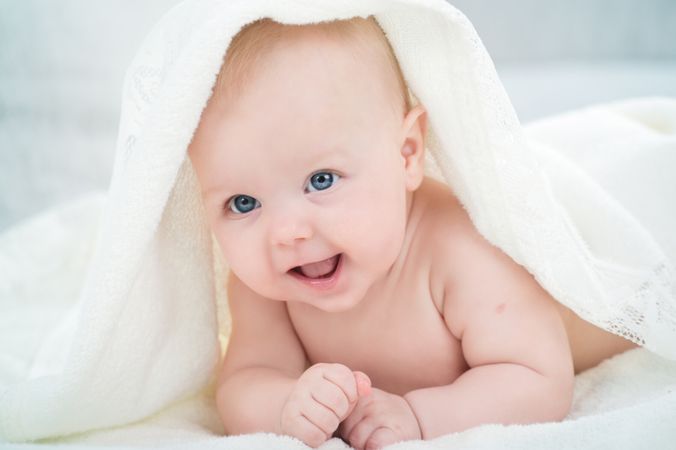 depositphotos 23869569 baby looking at camera under a white blanket